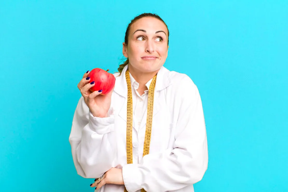 A person looking thoughtfully at a healthy meal, considering if they are in a calorie deficit.