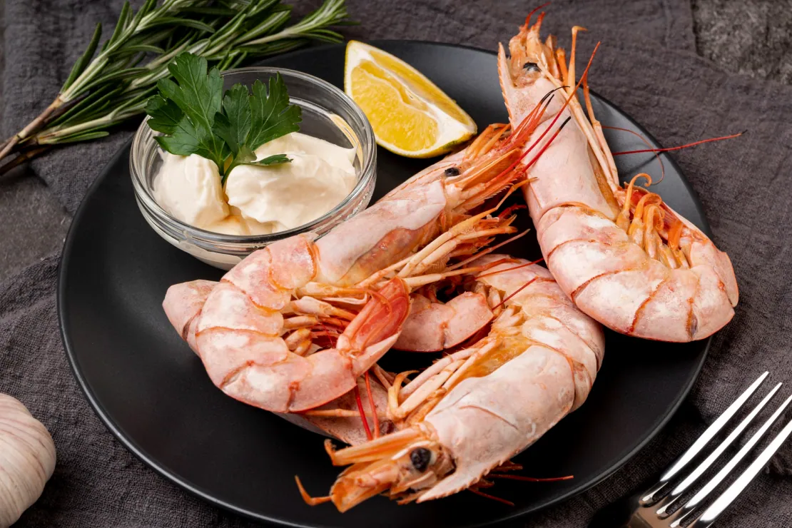 Cooked shrimp with lemon wedges and parsley, symbolizing a healthy, low-calorie protein source.