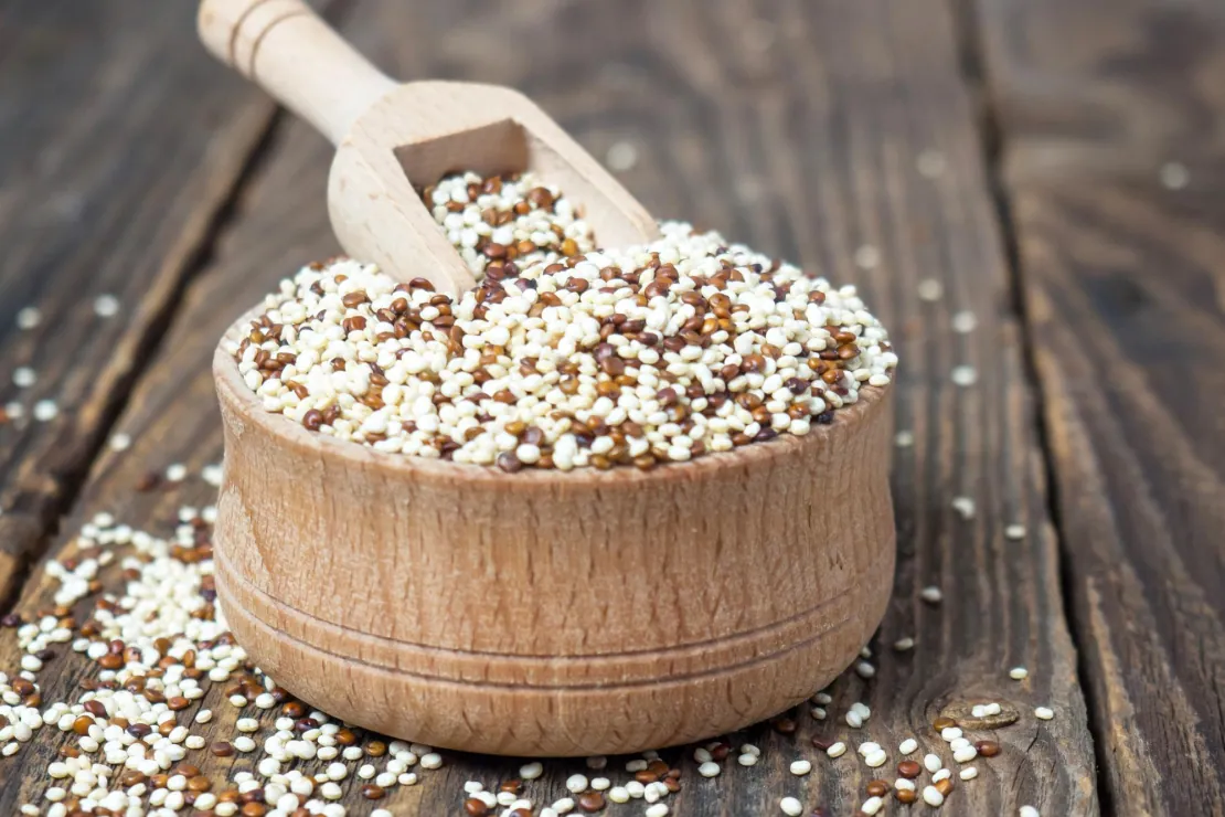 Bowl of cooked quinoa with vegetables and herbs, symbolizing a complete plant-based meal.