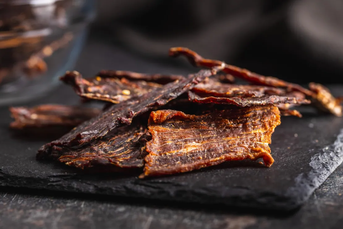 Assortment of jerky pieces in a bowl, symbolizing a convenient high-protein snack.
